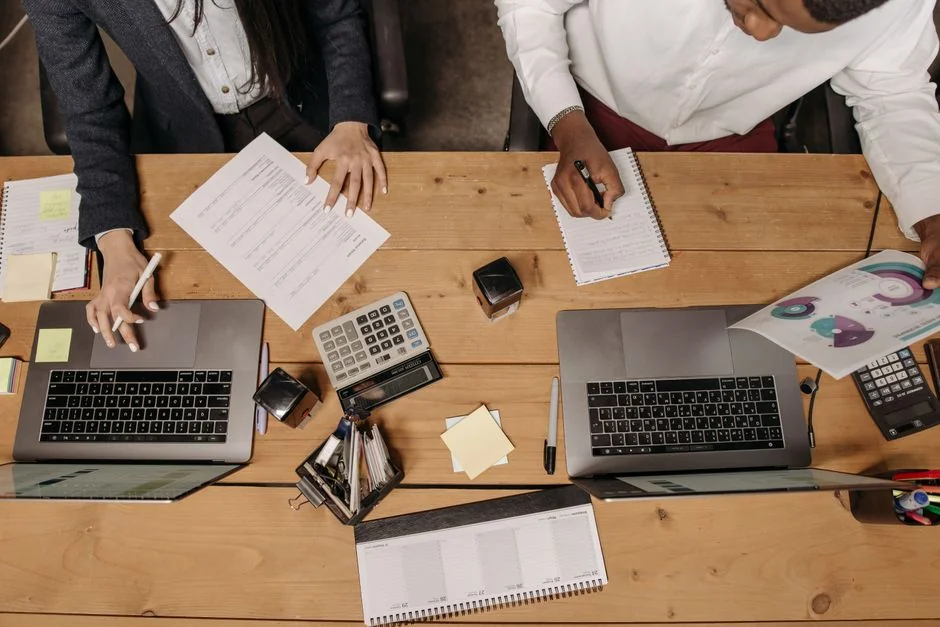 Une équipe diversifiée collabore autour de stratégies de marketing digital à un bureau, en utilisant des ordinateurs portables et des tablettes.